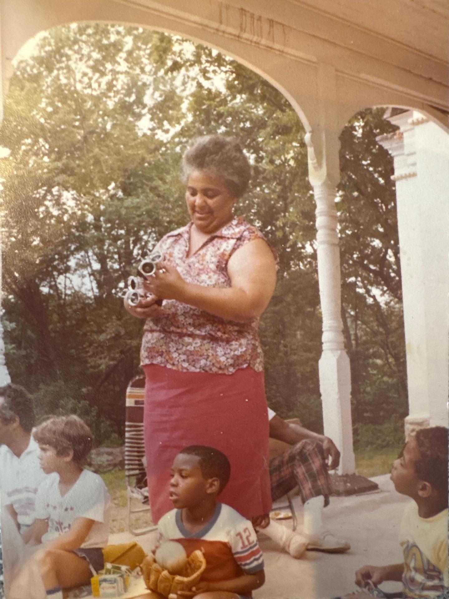 A grandmother on the porch with children gathered around